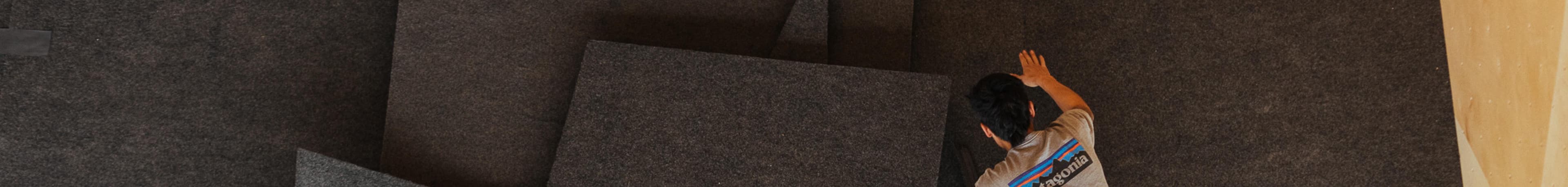 A man installing climbing route flooring seen from above