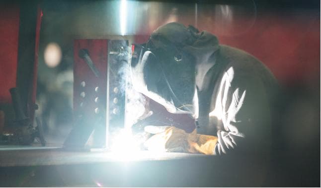A man welding in protective gear 