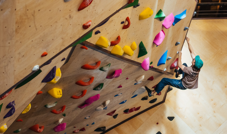 A man climbs on a sunny indoor climbing wall