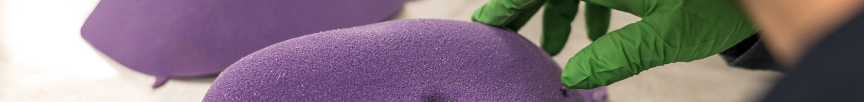 A Vertical Solutions employee inspects a tray of purple climbing holds
