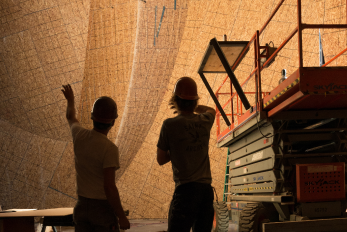Two construction workers standing in a climbing gym build site