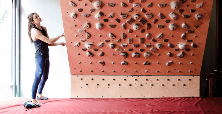 Woman adjusting a climbing training board angle