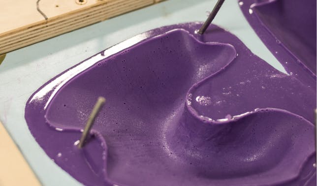 A purple climbing hold in its mold
