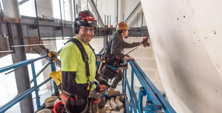 A Vertical Solutions employee poses with a nail gun