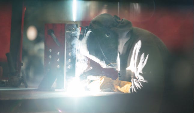 A man welding in protective gear 
