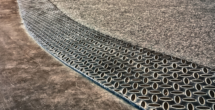 Diamond plate steel trim transition area between climbing floor and facility floor