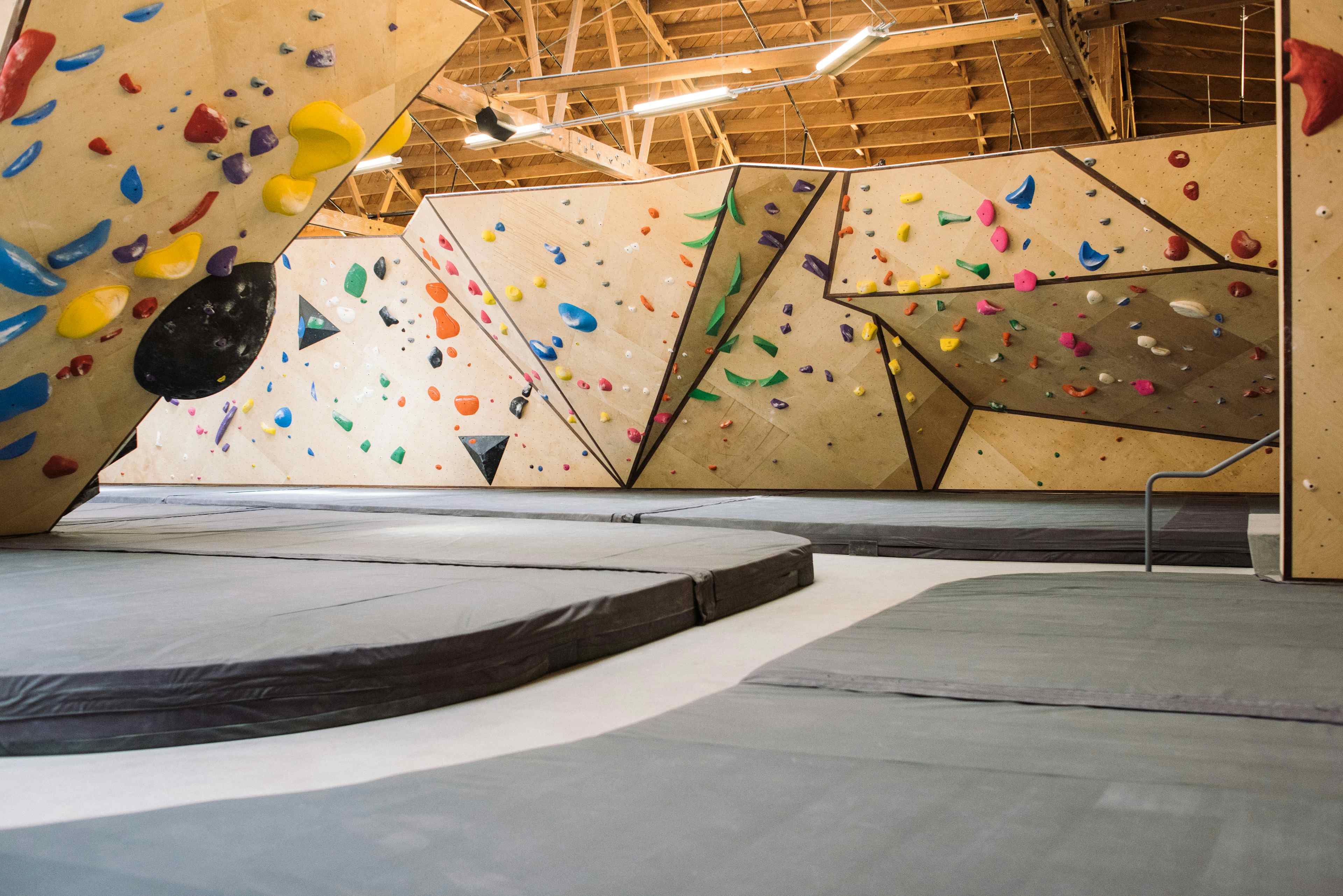 Custom climbing walls built by Vertical Solutions accompanied by Habit Flooring