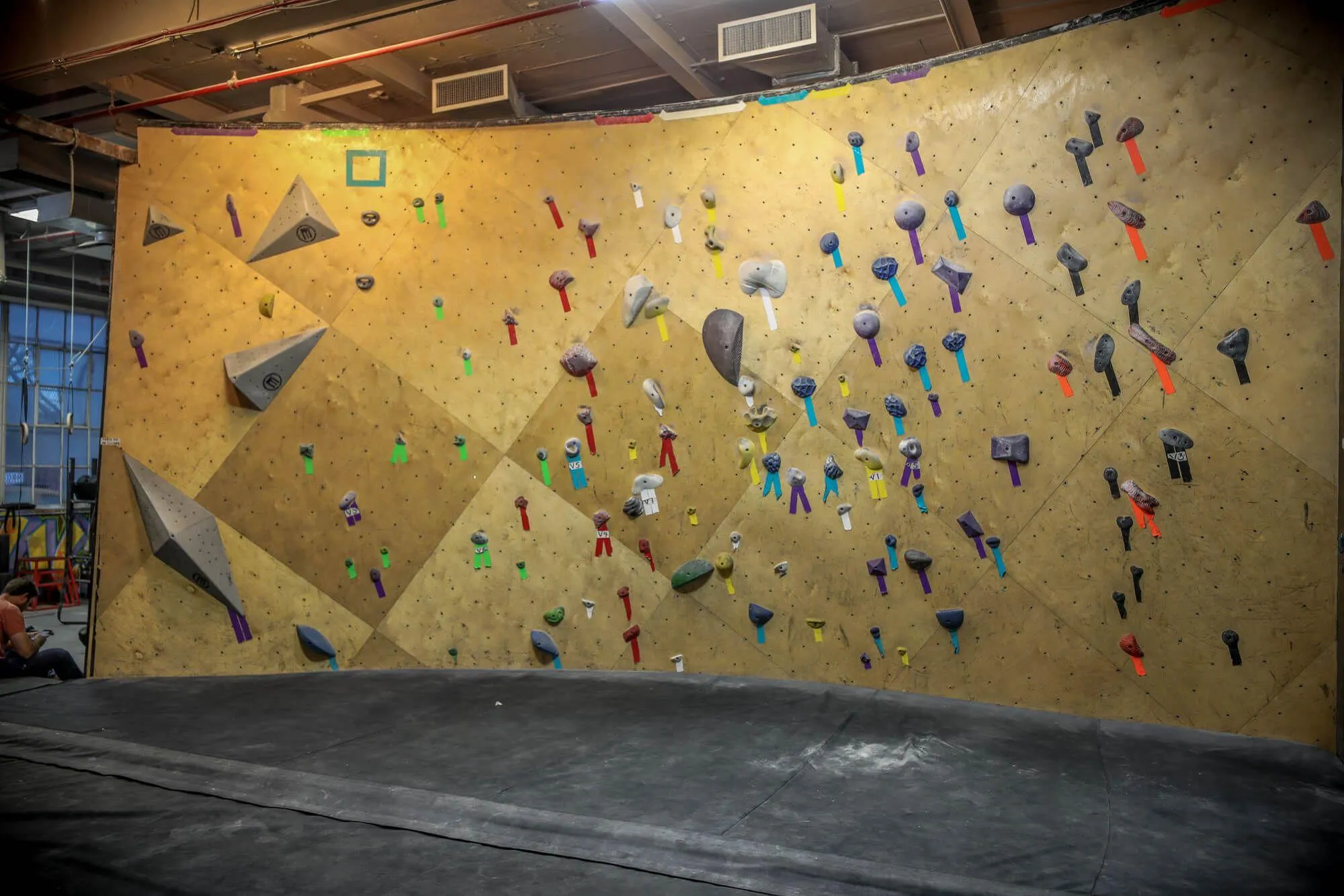 Beginner and intermediate bouldering members get their own dedicated space to familiarize themselves without being overwhelmed by others above their skill level. This Vertical Solutions-built wall is coupled with Habit Flooring system for a complete package.  
