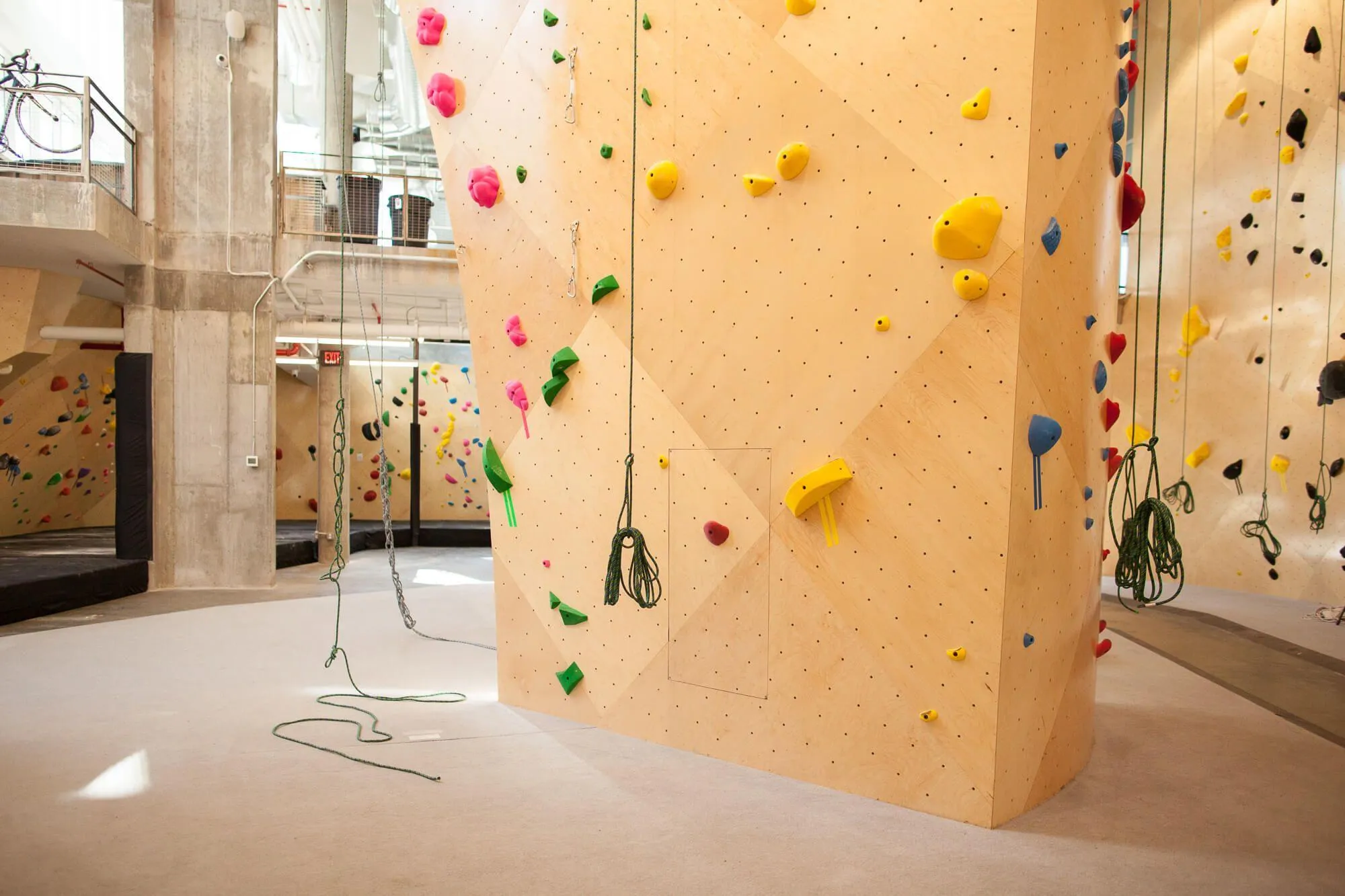 The base of one of the rope-climbing walls which starts below grand level in order to achieve the indoor climbing height.
