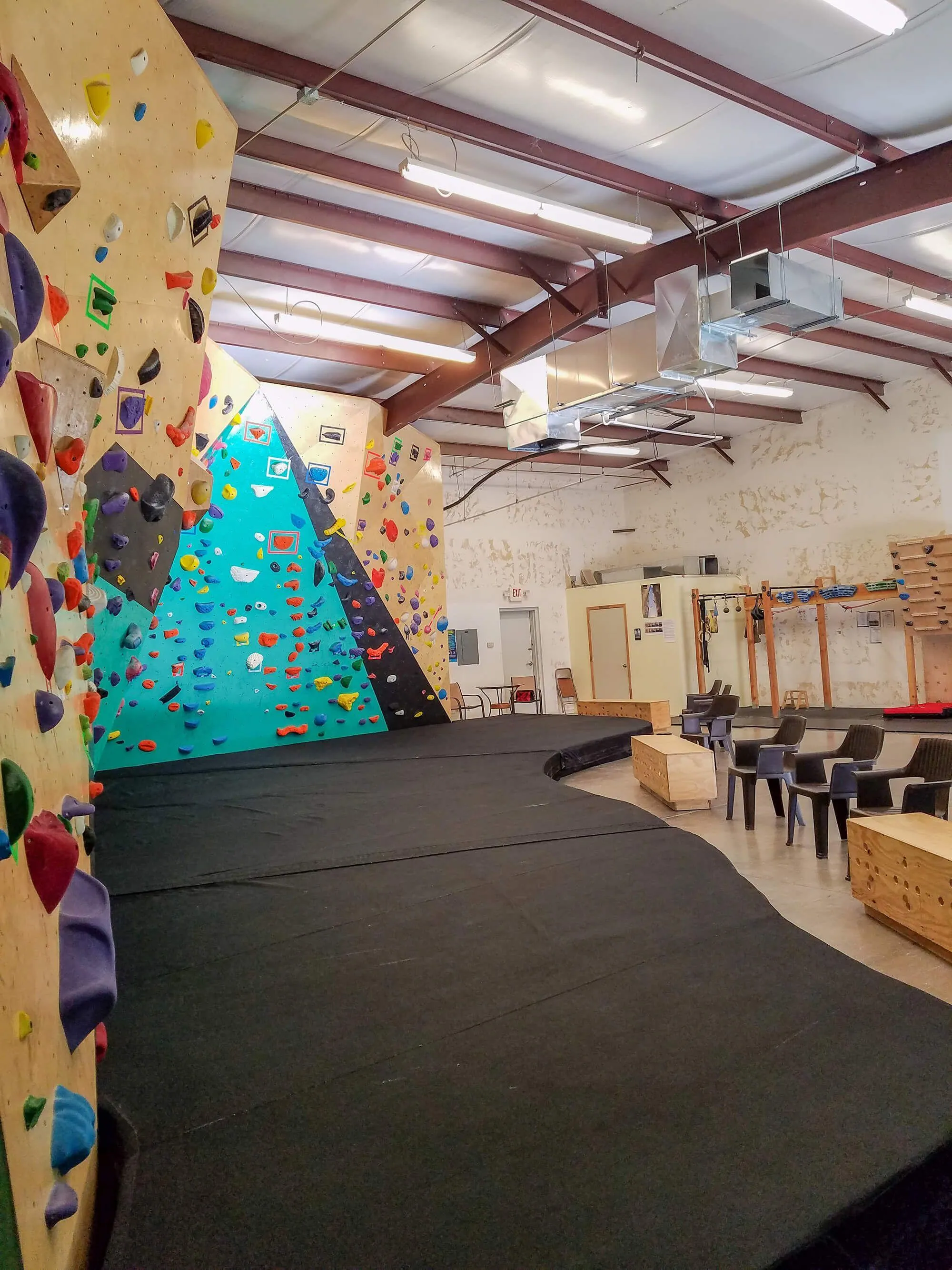 Packing in a lot of terrain in for such a small area means you have to be sure you have a great bouldering wall flooring system to arrest your climbers safely while falling. This side view shows the scale of the project and the varying levels of overhung geometric MLM climbing walls incorporated, as well as how big the Habit bouldering floor pad system is.
