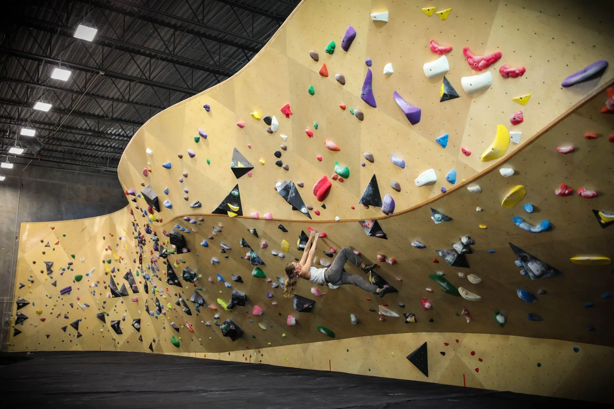 A wide view of the mezzanine level with a 100’ bouldering wall, which shows the smooth transition from vertical wall to deep overhung cave. Somehow this camera still isn’t capable of capturing how long this wall is while maintaining of one congruent surface from end-to-end.
