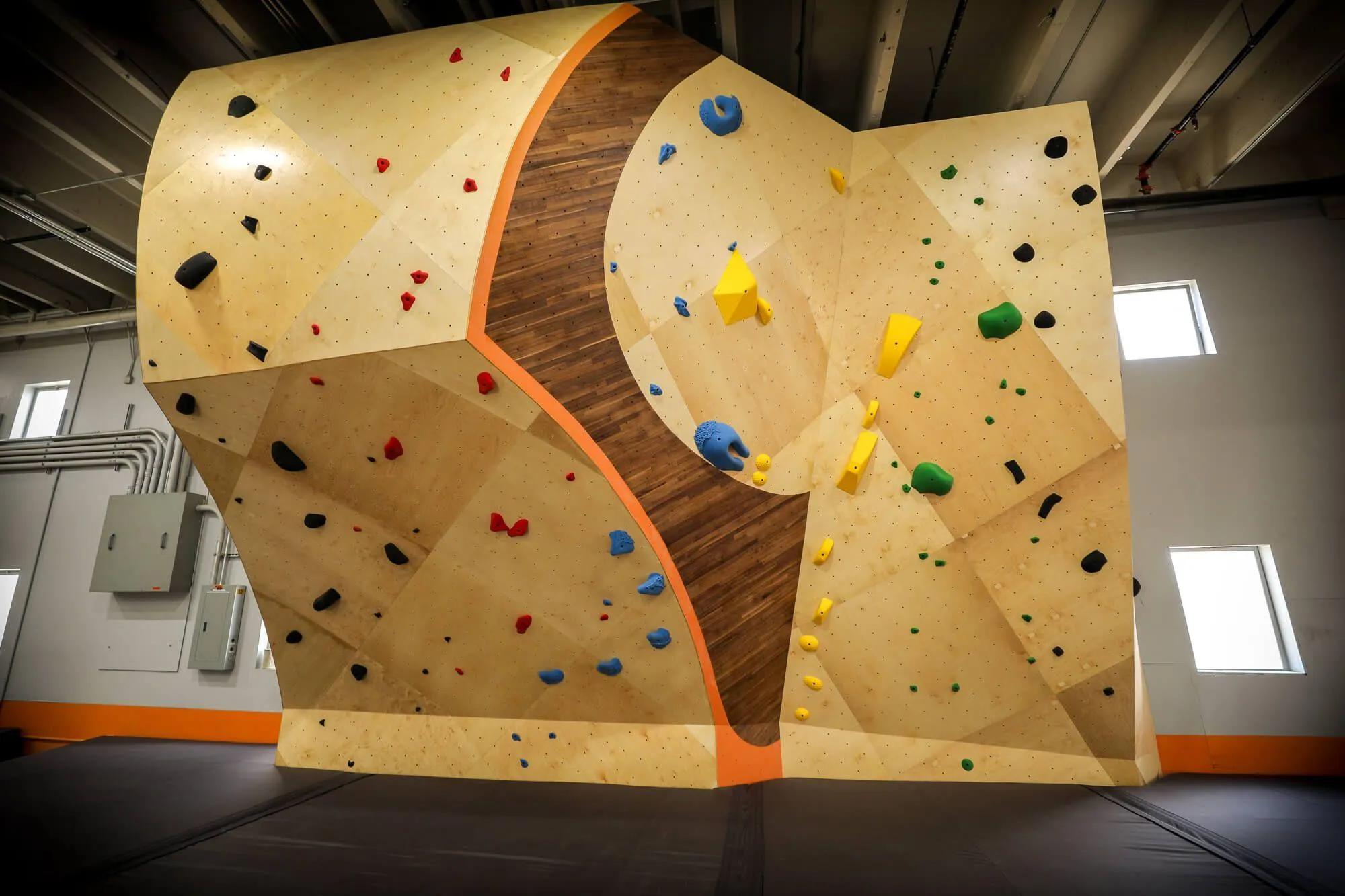 The ARC boulder has symmetrical hardwood and paint details on either vertical side. This type of branding is used throughout the climbing wall design, and is an unmistakable feature immediately noticeable.