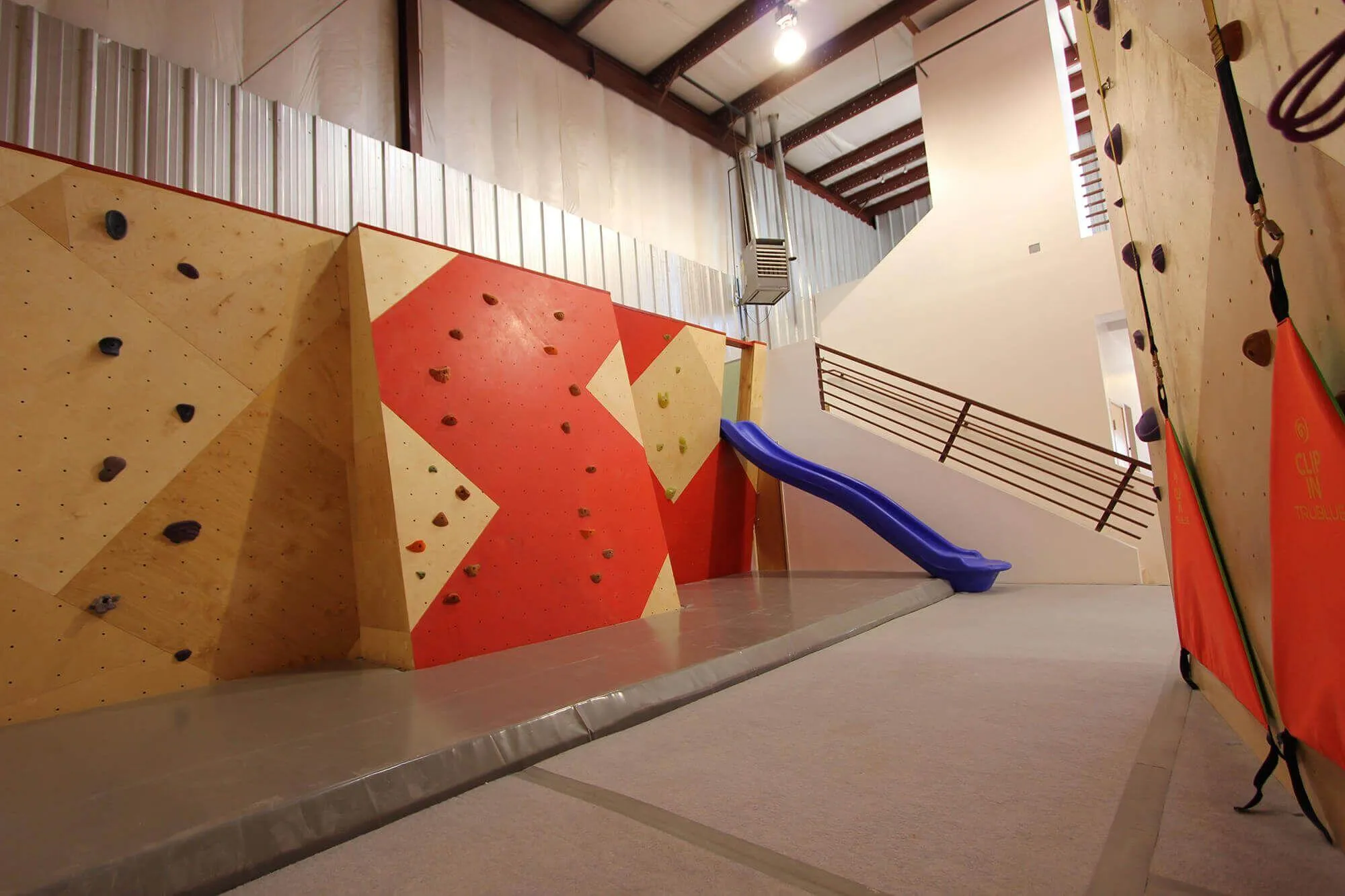 Just one of the ad hoc projects that can come up during a climbing wall build with Vertical Solutions: the owners took the extra panels and wanted to make another bouldering wall for little ones, complete with slide and all.
