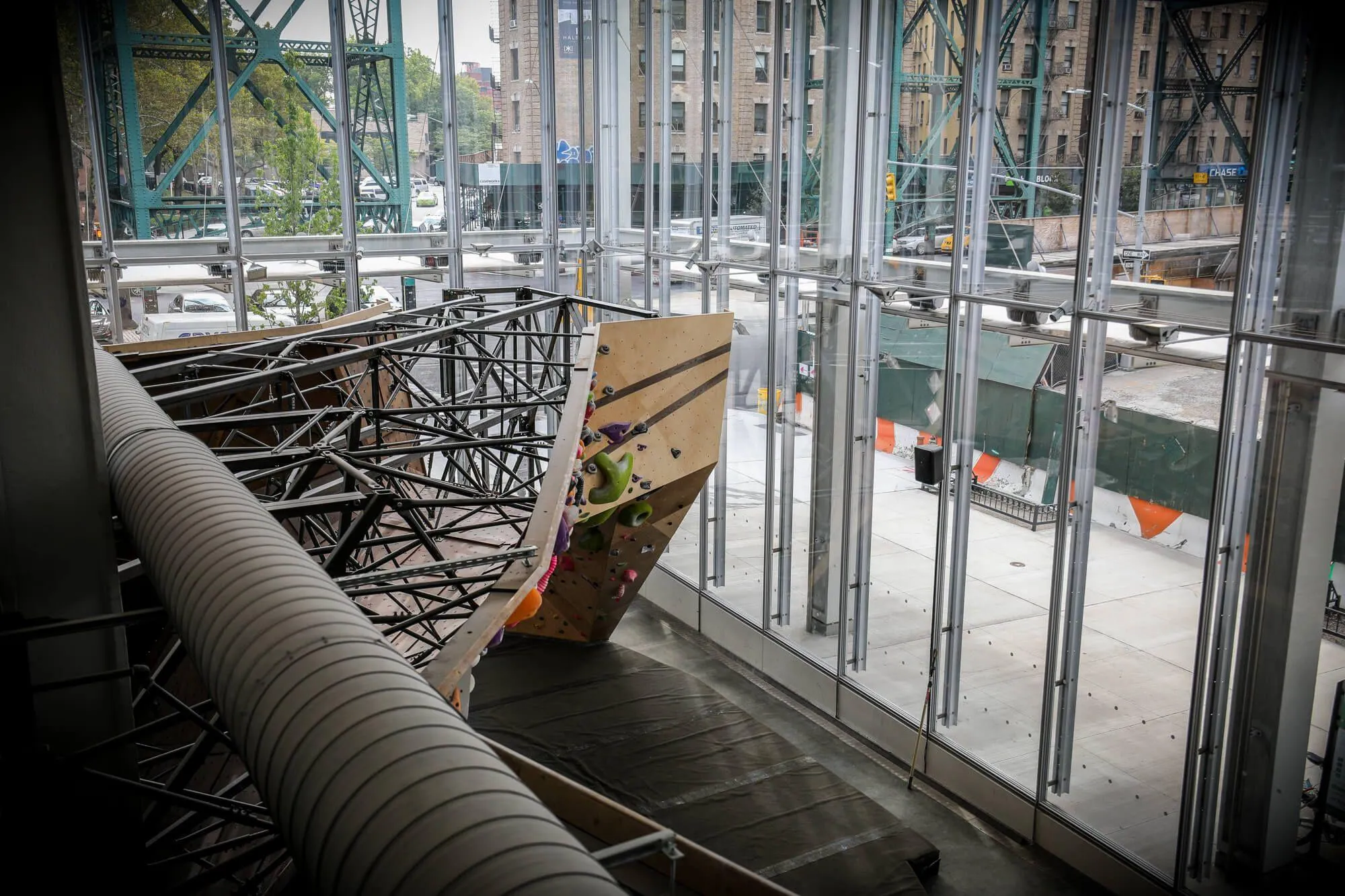 Creating an indoor climbing gym in an architecturally-stunning building such as this one has its challenges to compliment the inherent design. Vertical Solutions worked with owner Cesari to keep a partial view of the climbing wall structure visible to play-off the visible framework of the glass facade.
