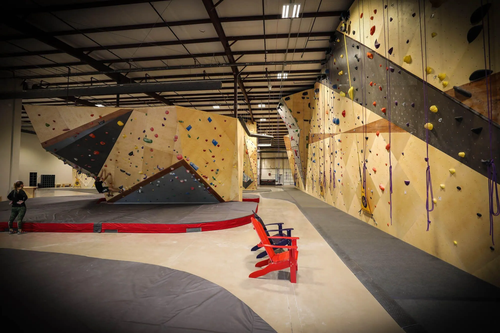 A view from one of the building's main corners showing just one of the route climbing walls which runs almost the entire length of the property. Iconic Adirondack chairs were placed throughout to give climbers a comfy reprieve from sending.
