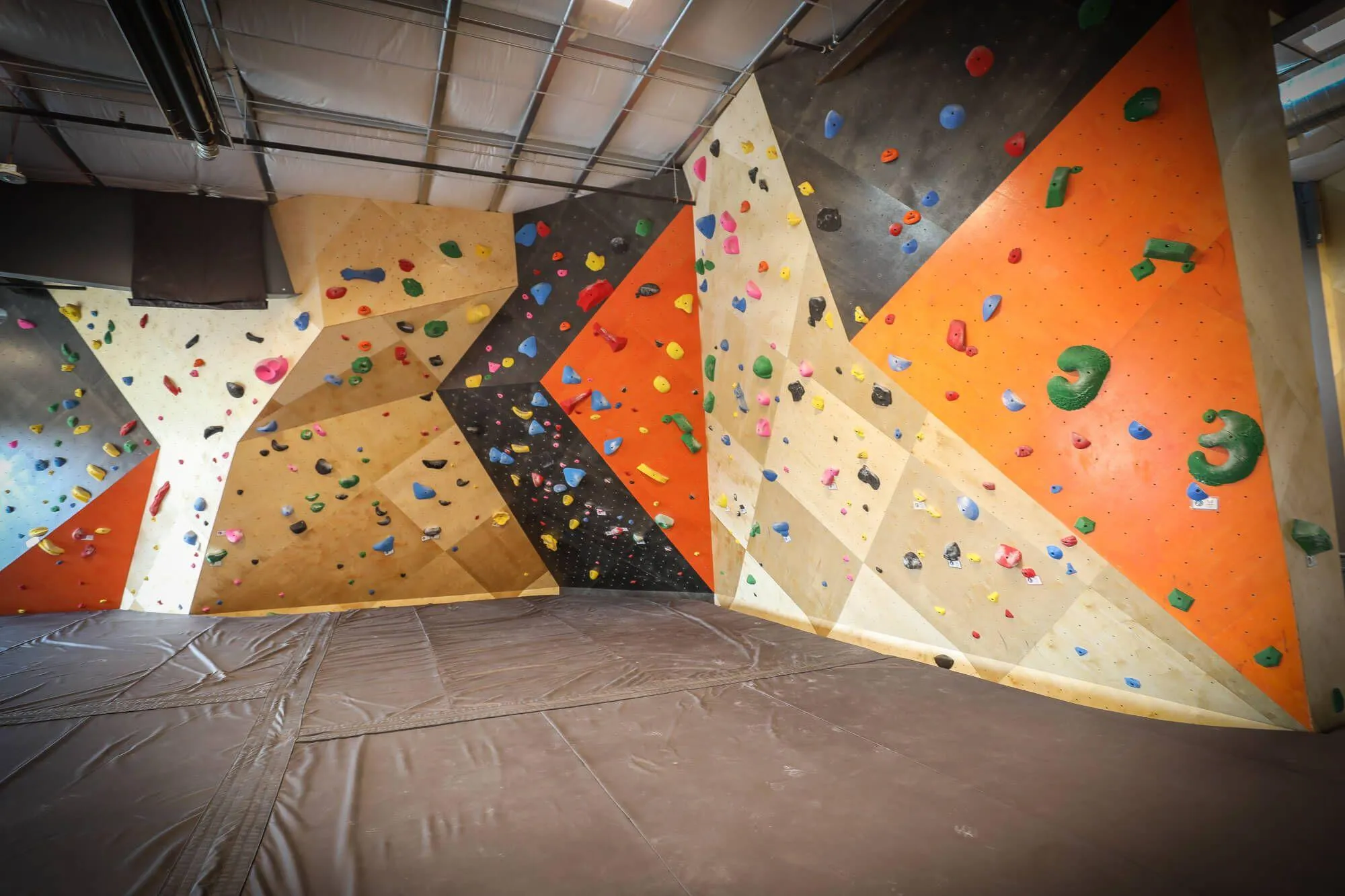 Another angle on one of the main upstairs bouldering walls, with custom stains and textures used all along the deceivingly-deep cave.
